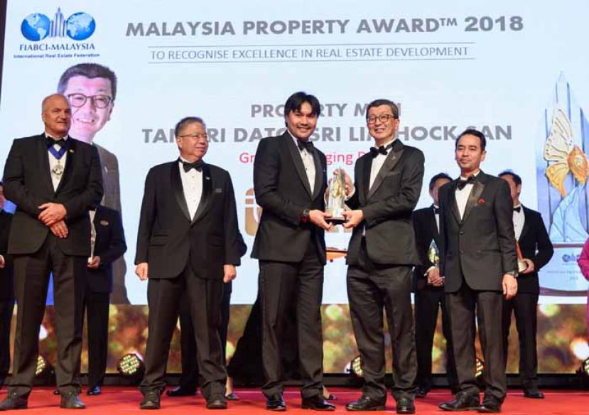 图示：林木生集团董事经理丹斯里林福山（左四）从森州王储东姑阿里礼道丁（左三）手中接过&ldquo;产业风云人物奖&rdquo;。左起为世界不动产联盟（FIABCI）主席艾盛麦克诺瓦、世界不动产联盟大马分会主席倪传鹏，以及马来亚银行消费者金融及社区金融服务主管莫哈末再尼。