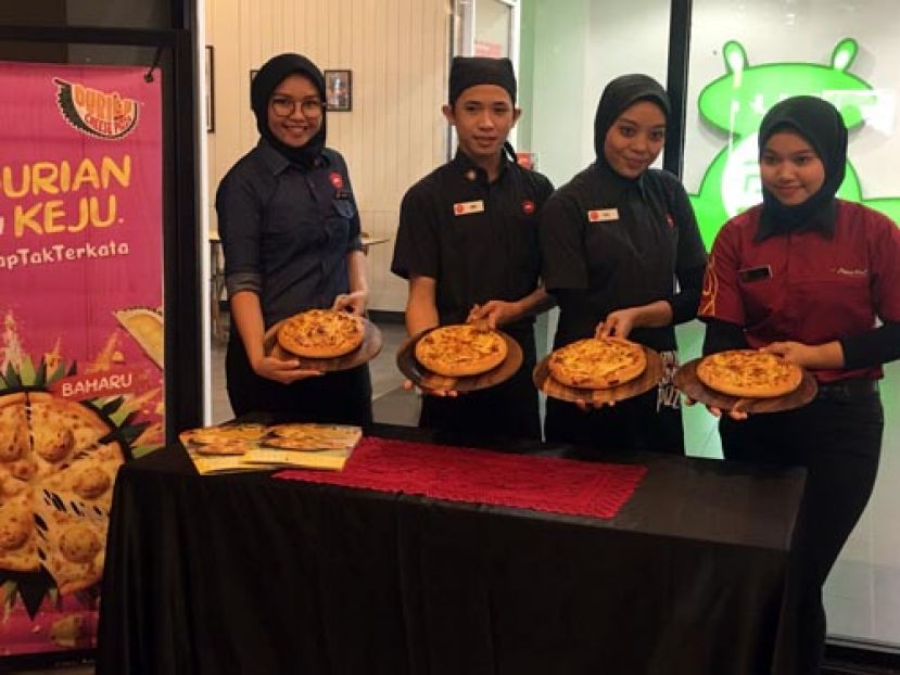 职员们展示全新榴莲披萨。