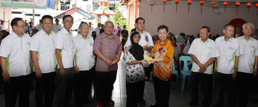 砂地方政府与房屋部长拿督沈桂贤（右四）派发礼品予受惠家庭，右五为砂云南善堂主席郑文新。