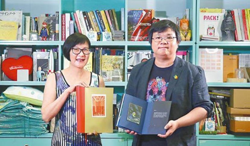 香港藏书票协会主席熊美仪（左）希望更多人投入藏书票创作与收藏的行列。旁为设计师蔡景康，他以粉丝身份为卫斯理创作全球首套立体藏书票。