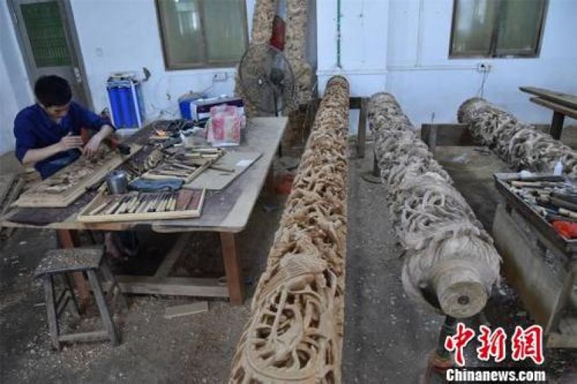 经过木雕艺人的巧手雕刻，祥云、花朵、麒麟、龙等图案逐渐显现。