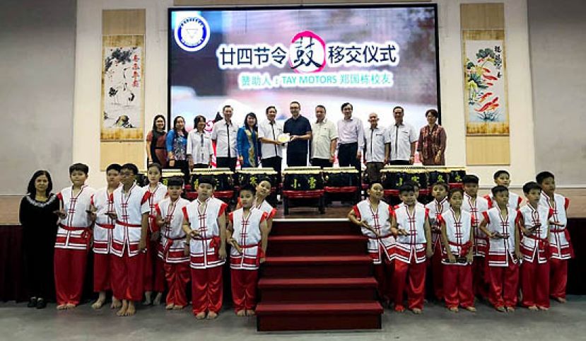 古晋三小97年毕业生郑国栋（右六）移交24节令鼓古晋中华小学校董会主席王长福（左六）。