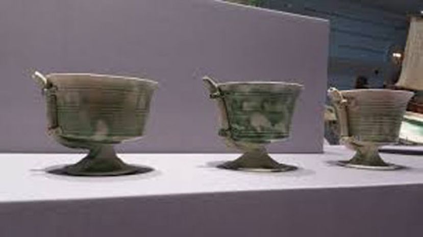 图示：唐代巩县窑制作的白釉绿彩瓷吸杯。外面有一根吸管与杯底相连。