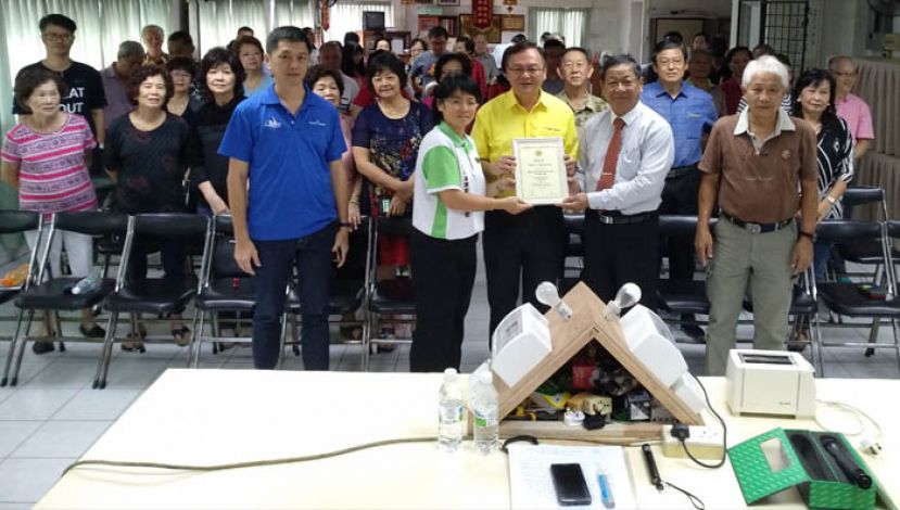 古晋惠东安公会自测漏电断路器讲座，右为该会会长兼主讲人周运华、青年团团长房宝丽(左)移交感谢状予罗克强时摄。
