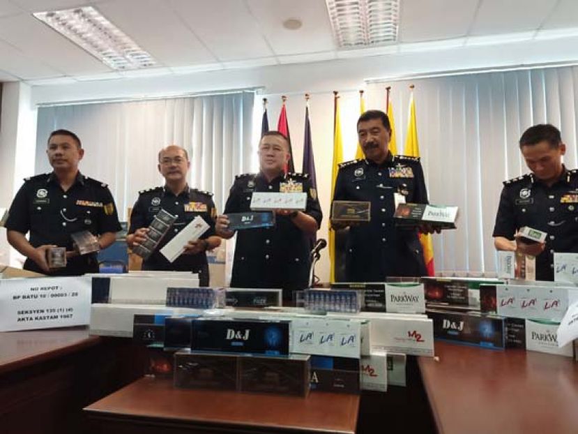 砂警察总监拿督兰利丁(中)展开&ldquo;战利品&rdquo;。
