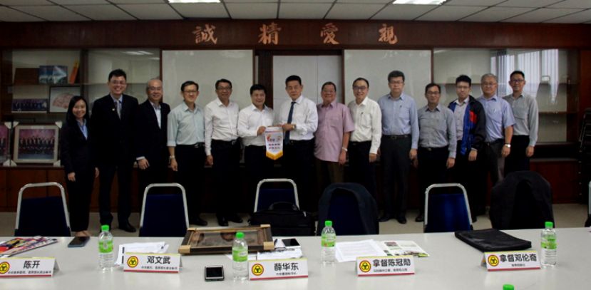 砂人联党教育局一行8人日前拜访董总进行交流，拿督陈冠勋（右八)与董总秘书长黄再兴交换纪念锦旗。(右七)是拿督邓伦奇。