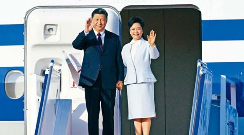 中国国家主席习近平与夫人彭丽媛踏出专机，向欢迎人群挥手致意。