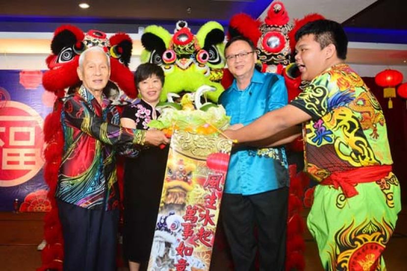 众人接过采青吉祥物，左起为该会会长甲必丹符气元、筹委会主席符燕芳及巴达旺市议会主席罗克强。