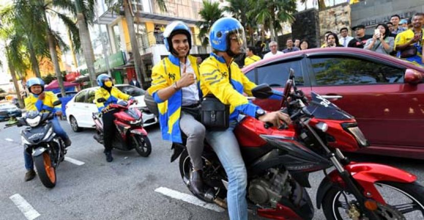 赛沙迪（右2）体验电召摩托车服务。