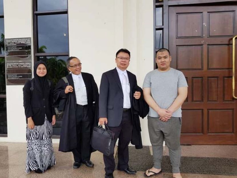 图示：因智商有缺陷而逃过死劫的查基哈兹(右)和辩护律师陈文达(右二)奥斯曼(右三)影于庭外。