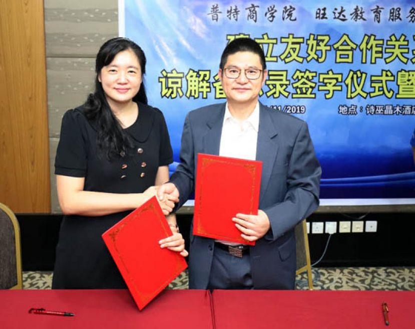 砂拉越旺达教育服务公司负责人李敏敏(左）於11月1 日在诗巫晶木酒店与浙江越秀外国语学院院长单胜江教授签署合作培养数字贸易人才谅解备忘录后交换文件。