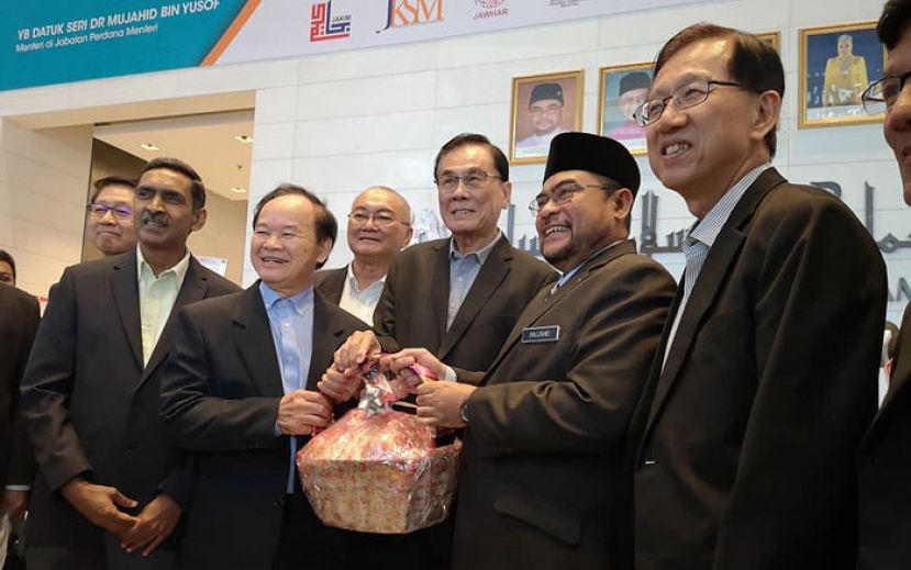 首相署部长拿督斯里慕扎希（右2）赠送水果篮给董教总代表王超群(右3)及陈大锦(左3)。