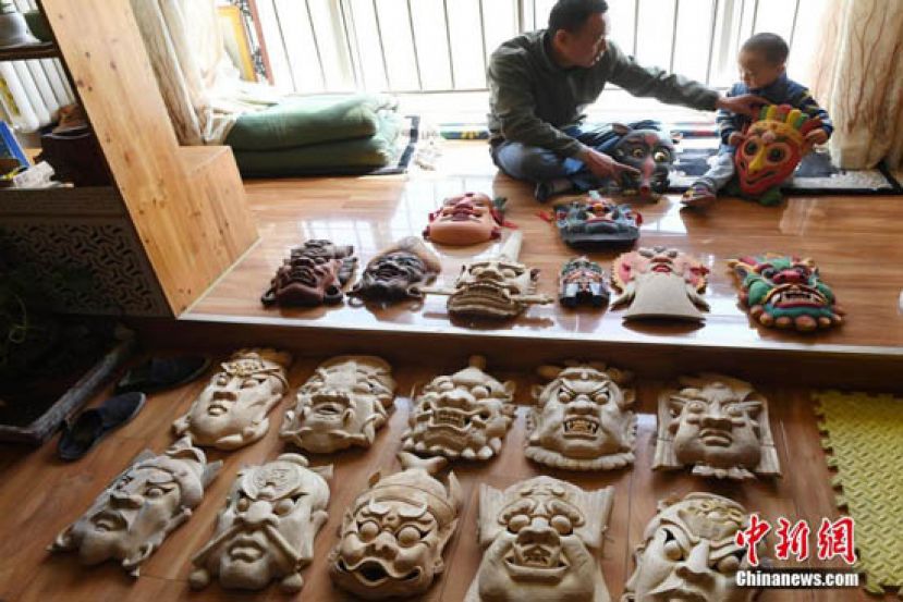 马正德在工作室里展示他制作的傩面具。