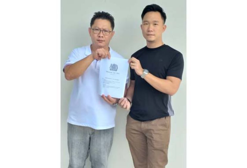 郑志国（左）展示英国刊印的1963年马来西亚契约，这份国际性合约是不允许任何单方面修改的。右为秘书符顺顺。