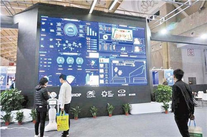 图示：在昆明举行的第二十届中国零售业博览会上，智慧零售受到观众青睐。图为机器人导购在与观众互动。 