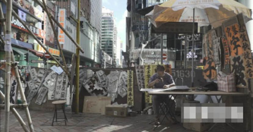 伍文锡七十年代由大陆来港，发现旺角亚皆老街及砵兰街的书法街，搬一张桌开档，小时候的习字兴趣竟成为终生职业，一坐四十年。