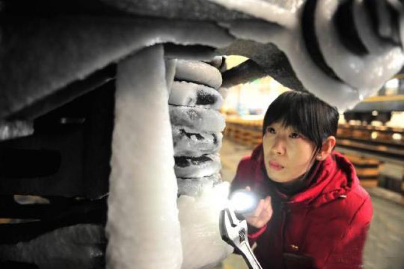 图示：高燕敏清除列车注水口位置的结冰。　