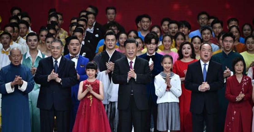 中国国家主席习近平(中)、候任澳门特首贺一诚(右二)和即将卸任特首的崔世安在舞台上与众表演者高歌一曲。