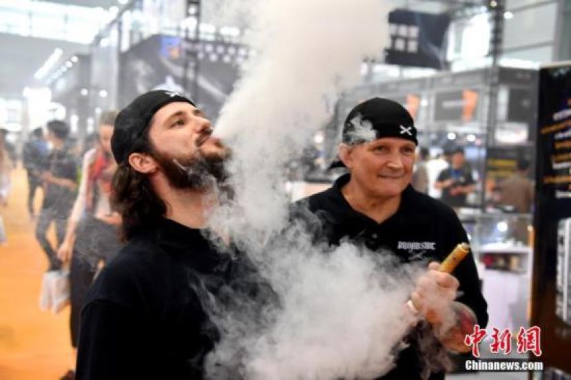 资料图：电子烟参展商男子现场展示。