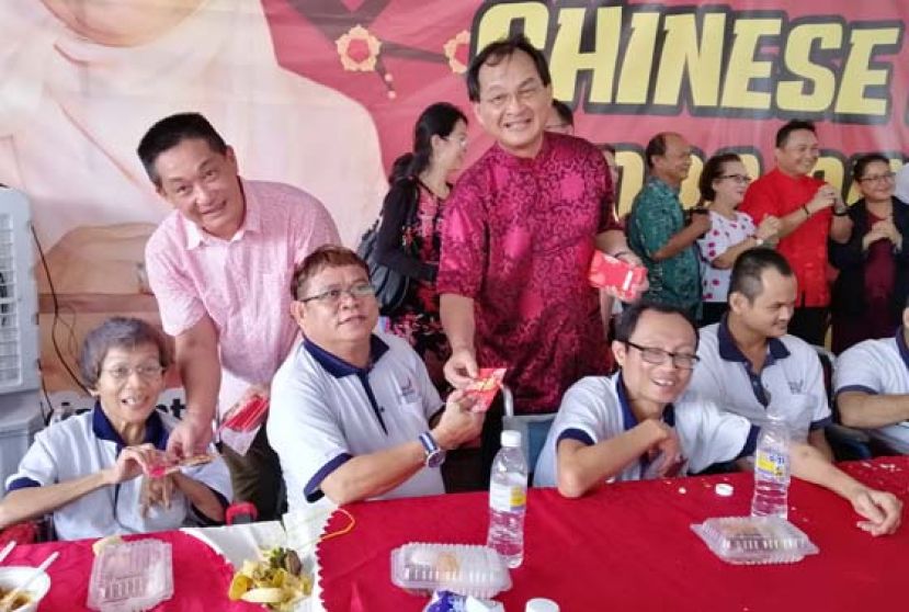 联邦工程部长兼砂公正党主席巴鲁比安(站立左2)在砂公正党新春团拜上与民众握手互相贺岁，左1位巴都林党区州议员施志豪。