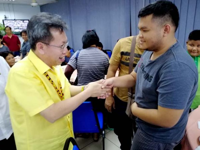  砂地方政府兼房屋部长拿督沈桂贤（左）与实都东达雅小贩开心握手问好。