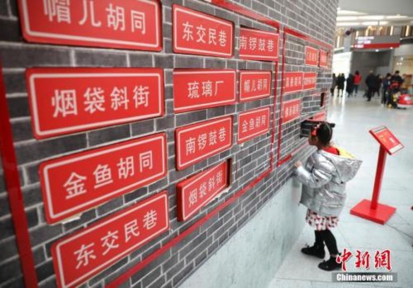 北京某商场内，一位小女孩在翻看胡同名字。