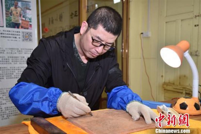 图示：吴育琳用刻刀绘就&ldquo;泉州红&rdquo;，传承优秀的闽南文化。