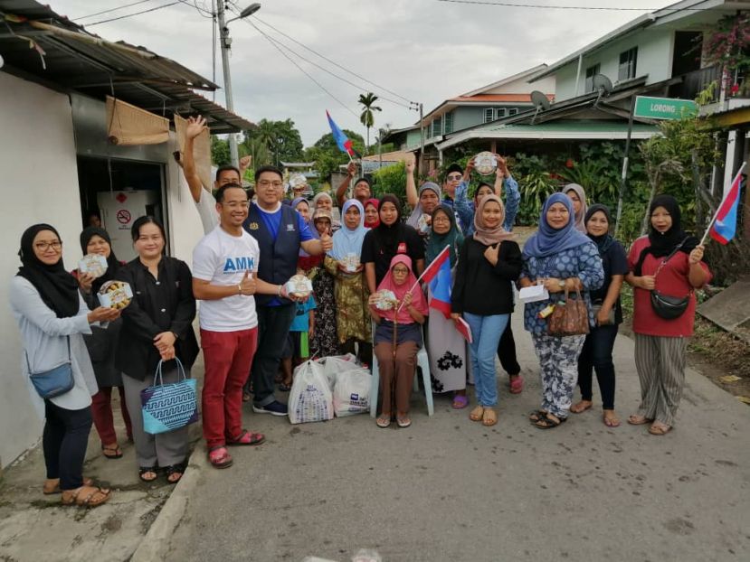 砂人民公正党副主席温夏妮（左三）、莫惠中（左五）派送&ldquo;微笑礼盒&rdquo;于巴都吉当甘榜丽达答纳的贫户后与村民合照。