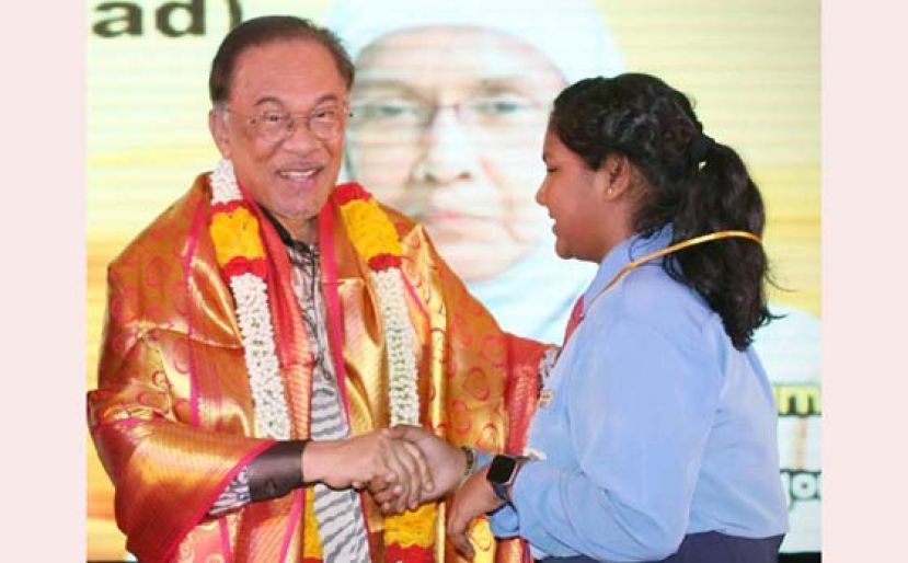 安华（左）颁发金牌给在小六鉴定考试表现优异的淡小生。