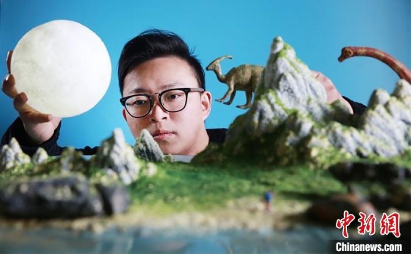 丁洲在做微缩摄影作品布景。