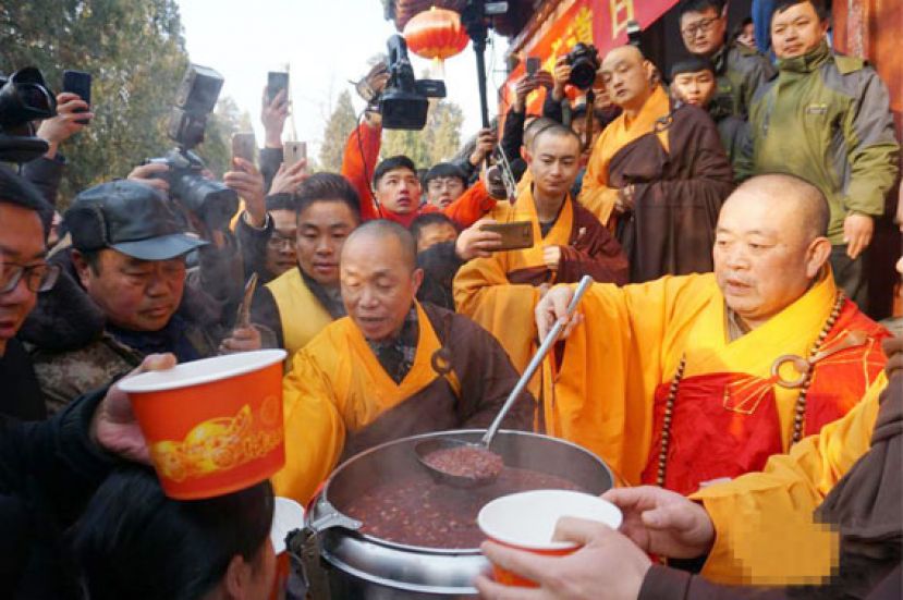 图示：河南嵩山少林寺方丈释永信为游客施腊八粥。