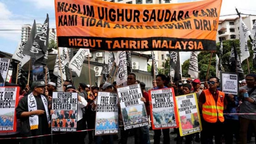 游行队伍高举横幅与海报，并高喊口号。