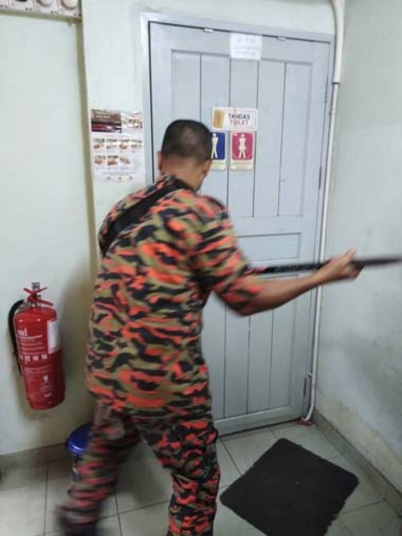 消拯员以铁斩撬开厕所门。