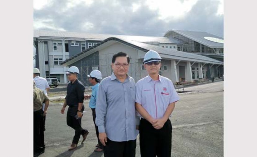 吴标生（左）與李文材巡视医院工程进展后合影。