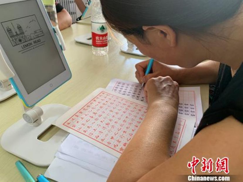 正在书屋内练习写字的村民。