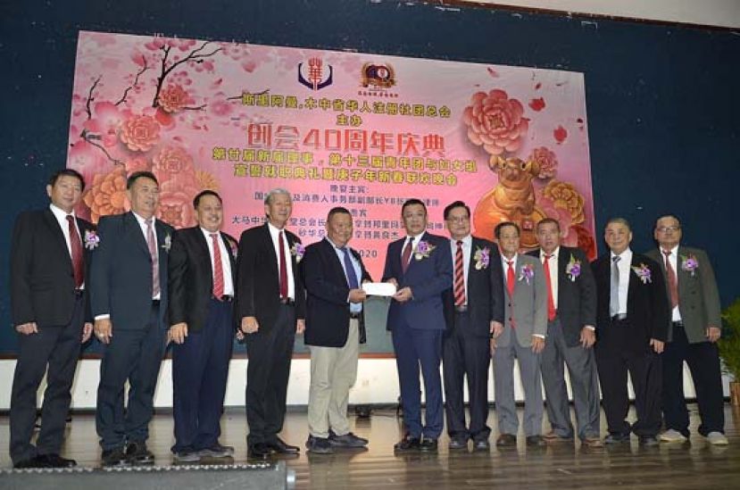 砂华总会长拿督黄良杰（右6）移交支票予斯木省华总财政郑瑞通。