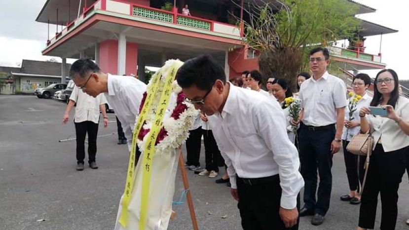 中国驻古晋总领事程广中（右）及副领事张阳（左）出席纪念南侨机工抗战80周年，在机工英雄纪念碑前献上花圈及鞠躬。