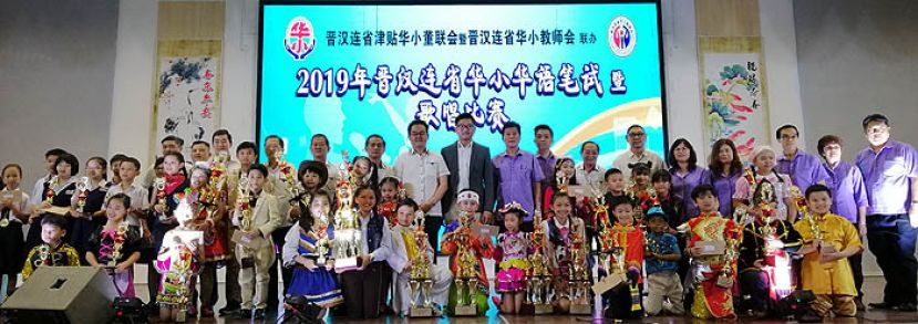 2019年晋汉连省华小笔试暨歌唱比赛，优胜得奖学生与嘉宾合影。后排右十为浮罗岸区州议员黄庆伟（后排右十）和晋汉连省华小董联会署理会长田松茂(右十一)。