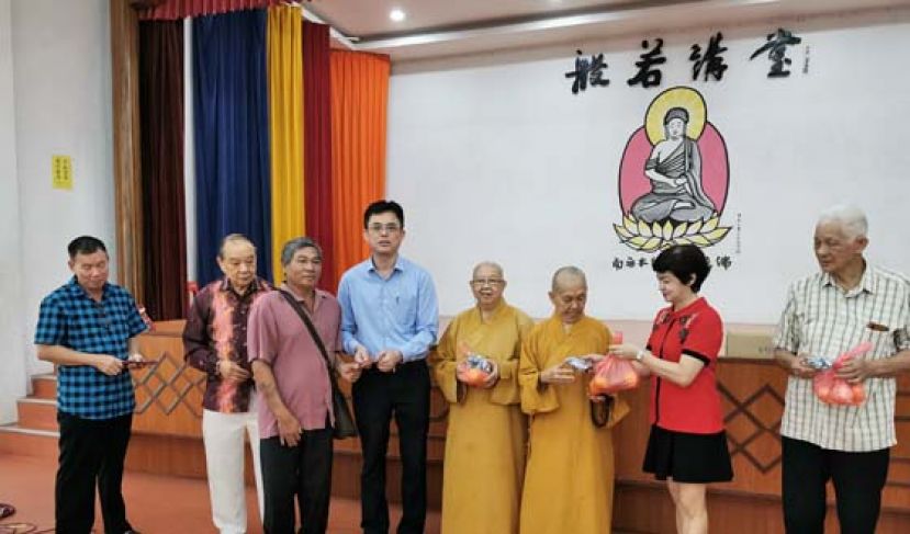 砂首长政治秘书陈开（左4）分发新春红包给其中一户巫裔受惠者，左2为古晋佛教居士林林长蔡明田。