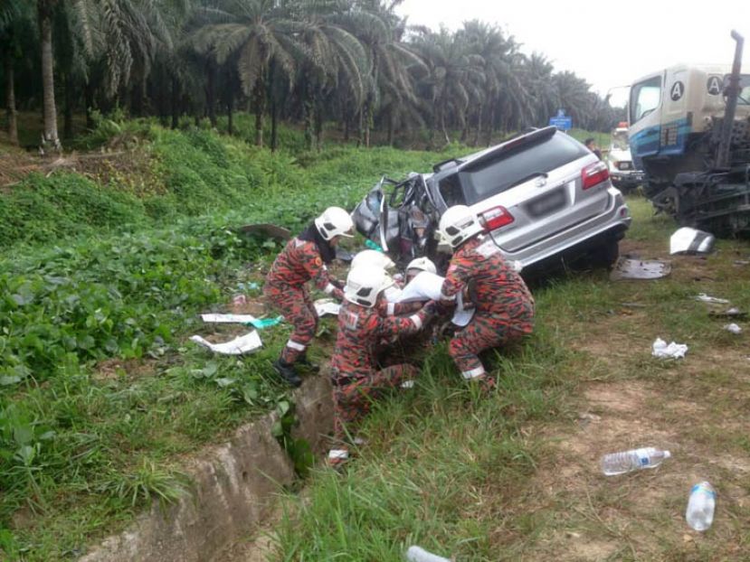 车祸现场，拯救人员将其中一名死者遗体从车中移出。