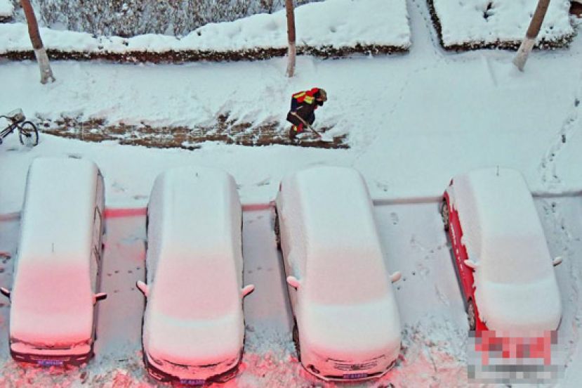 图示：7日，环卫工人在山东省烟台市福山区街头清理积雪。