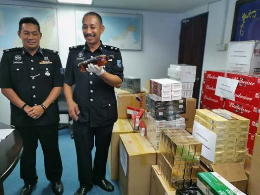砂水警副指挥官阿邦拉曼（右）展示在行动中破获的逃税私烟酒。
