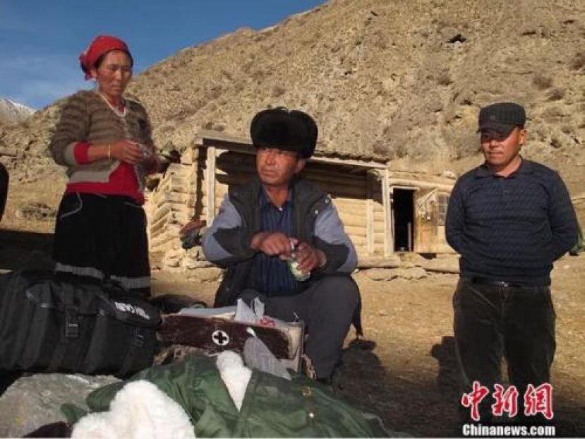 居马泰&middot;俄白克（中）在包扎墩牧区牧民发放药品。