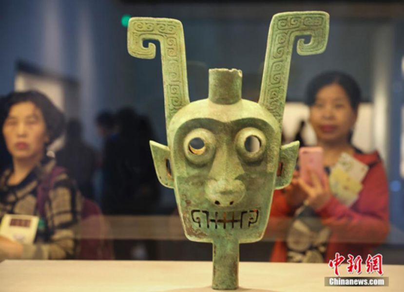 图示：观众欣赏双面神人青铜头像。
