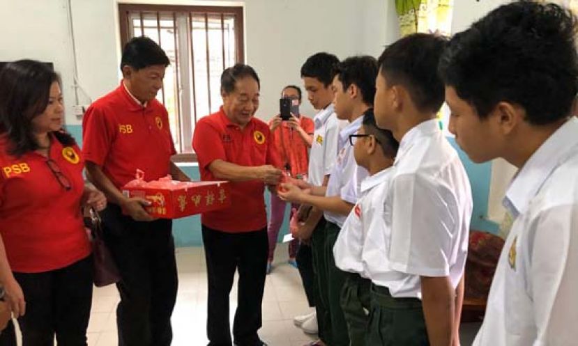 砂全民团结党主席拿督斯里黄顺舸（左三）派发新年礼品予男童之家的学生。