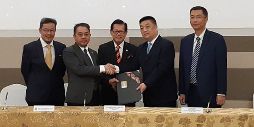  签署仪式完毕后,砂交通部长拿督李景胜(中)见证双方代表,即砂经济发展局主席丹斯里阿都阿兹(左2)与中国广东省佛山市飞驰汽车制造有限公司董事总经理江勇(右2)移交协议合作备忘录。右为中国广东省佛山市飞驰汽车制造有限公司海外市场总监周嘉栋。