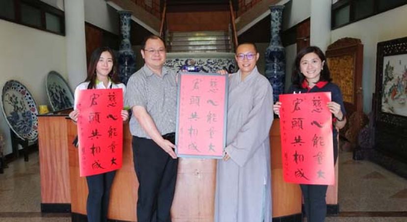 文殊佛学院院长释传灯法师（右二）把春联移交予本报业务经理陈朝忠（左二）时摄。右一为大马佛教大学讲师刘圆言。