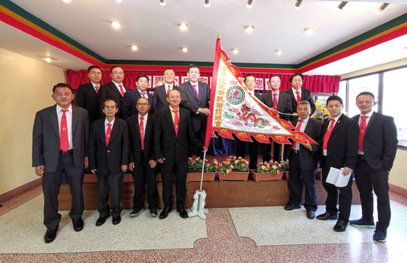 世界沈氏宗亲联谊会总主席沈茂强（后排右四）从首届主席沈木盛（后排右三）手中接过会旗。