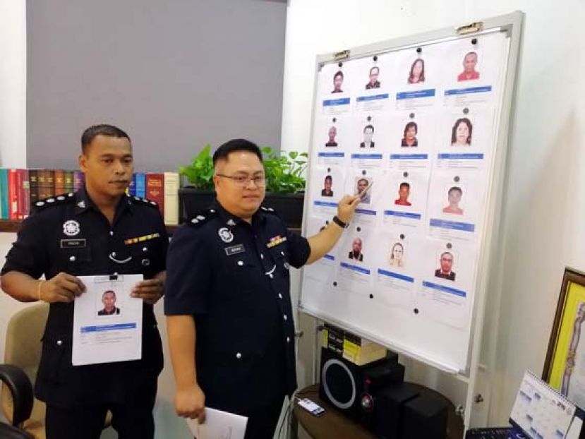 砂警察商业罪案调查组主任慕兹达法警监（右）向媒体展示通缉犯的照片和资料，(左)副主任力查。