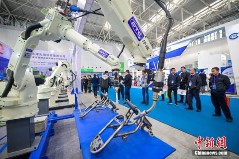 图示：观众参观工业机器人。